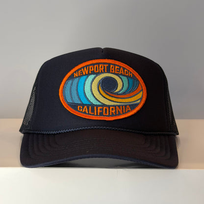 Navy blue trucker hat with a colorful Newport Beach California embroidered logo on a patch.